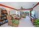 Comfortable living room with rattan furniture, ceiling fan, and sliding door access to balcony at 2060 Willow Hammock Cir # 301, Punta Gorda, FL 33983