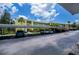 Covered parking area of yellow condo with parking spaces and a well-maintained landscape at 2060 Willow Hammock Cir # 301, Punta Gorda, FL 33983