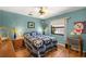 Comfortable bedroom featuring wood floors, a ceiling fan, a window overlooking the garden and blue colored walls at 2152 Taiwan Ct, Punta Gorda, FL 33983