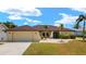 Charming single-Gathering home featuring an attached garage, front yard and mature palm trees at 2152 Taiwan Ct, Punta Gorda, FL 33983