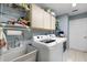 This laundry room offers a sink, washer, dryer, cabinet storage and tiled floors at 2152 Taiwan Ct, Punta Gorda, FL 33983