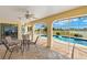 View of covered patio with outdoor table seating overlooking in ground pool, lake and backyard at 2152 Taiwan Ct, Punta Gorda, FL 33983