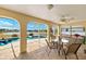 A covered patio featuring an outdoor table and seating overlooking the in-ground pool and lake at 2152 Taiwan Ct, Punta Gorda, FL 33983