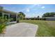 Large backyard with lush green grass and minimal landscaping, and concrete patio at 2166 Beacon Dr, Port Charlotte, FL 33952