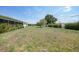 Large backyard with lush green grass, minimal landscaping, and mature trees at 2166 Beacon Dr, Port Charlotte, FL 33952