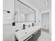 Modern bathroom featuring a double vanity, sleek black fixtures, tiled floors, and modern mirrors at 2166 Beacon Dr, Port Charlotte, FL 33952