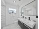 Modern bathroom featuring a double vanity, sleek black fixtures, and tiled floors and walls at 2166 Beacon Dr, Port Charlotte, FL 33952