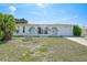 Charming single-story home boasts arched entryway, attached garage, and well-maintained front yard at 2166 Beacon Dr, Port Charlotte, FL 33952