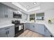 Updated kitchen features grey cabinets, stainless steel appliances, white countertops and backsplash at 2166 Beacon Dr, Port Charlotte, FL 33952