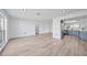 Spacious living room featuring sleek flooring and an open layout, leading to a modern kitchen with stainless steel appliances at 2166 Beacon Dr, Port Charlotte, FL 33952