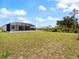 Spacious backyard with a screened-in patio and lush green lawn at 223 Australian Dr, Rotonda West, FL 33947