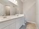 This bathroom has double sinks, white cabinets and hard surface floors at 223 Australian Dr, Rotonda West, FL 33947