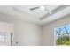 A modern bedroom features tray ceilings, ceiling fan and natural light at 223 Australian Dr, Rotonda West, FL 33947