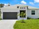 Charming single Gathering home featuring a grey exterior, two-car garage, and a well manicured lawn at 223 Australian Dr, Rotonda West, FL 33947