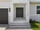 A close up of a front entrance with a black double door, light fixture, garage door, and garden at 223 Australian Dr, Rotonda West, FL 33947