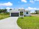 View of house with a grey front door, garage door, modern windows, front yard, and concrete driveway at 223 Australian Dr, Rotonda West, FL 33947