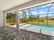 The screened patio is connected to the pool and looks onto a large grassy field at 223 Australian Dr, Rotonda West, FL 33947