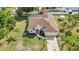 Aerial view of the property featuring a well-manicured lawn, a home with a brown roof, and lush landscaping at 2300 Carpenter Ln, North Port, FL 34286