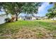 Expansive backyard with mature trees, white fencing, and a screened lanai at 2300 Carpenter Ln, North Port, FL 34286