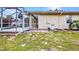 Spacious backyard with a screened-in pool area, brick patio, and lush lawn at 2300 Carpenter Ln, North Port, FL 34286