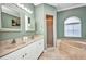 Bathroom featuring double sinks, a shower, and a bathtub at 2300 Carpenter Ln, North Port, FL 34286