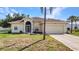 Beautifully landscaped home featuring a manicured lawn, lush landscaping, and an attached two-car garage at 2300 Carpenter Ln, North Port, FL 34286