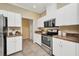 Bright kitchen with white cabinetry, stainless steel appliances, and tile flooring at 2300 Carpenter Ln, North Port, FL 34286