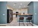 Open-concept kitchen with breakfast bar, stainless appliances, and tile flooring at 2300 Carpenter Ln, North Port, FL 34286
