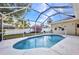 The pool is fully screened with a beautiful backyard view and a lovely garden beyond the enclosure at 2300 Carpenter Ln, North Port, FL 34286