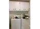 A functional laundry room with washer, dryer, and upper cabinets for storage at 23220 Rountree Ave, Port Charlotte, FL 33980