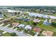 Bird's-eye view of a community near a lake featuring multiple homes with pools and screen enclosures at 2442 Rio De Janeiro Ave, Punta Gorda, FL 33983