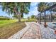 Brick path alongside beautifully landscaped backyard and pool at 2442 Rio De Janeiro Ave, Punta Gorda, FL 33983