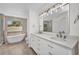 Luxurious bathroom with dual sinks, soaking tub, and walk-in shower at 2442 Rio De Janeiro Ave, Punta Gorda, FL 33983