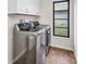 Bright laundry room features modern washer, dryer and wooden floor at 2442 Rio De Janeiro Ave, Punta Gorda, FL 33983