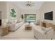 Bright living room with neutral décor, ceiling fan, and sliding glass doors to the pool area at 2442 Rio De Janeiro Ave, Punta Gorda, FL 33983