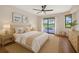Serene main bedroom with a view of the pool, wood floors, and neutral bedding at 2442 Rio De Janeiro Ave, Punta Gorda, FL 33983
