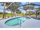 Inviting screened-in pool area with a spacious pool, spa, and beautiful backyard views at 2442 Rio De Janeiro Ave, Punta Gorda, FL 33983