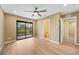 Spacious bedroom featuring wood-look flooring, ceiling fan, and access to screened patio at 2486 Caring Way # 14A, Port Charlotte, FL 33952