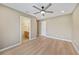 Bright bedroom with wood-look flooring, ceiling fan, and ensuite bathroom at 2486 Caring Way # 14A, Port Charlotte, FL 33952