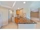 Open concept kitchen features granite countertops, tile backsplash, and adjacent laundry room at 2486 Caring Way # 14A, Port Charlotte, FL 33952