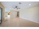 Spacious open-concept room features tile flooring, a ceiling fan, and a glimpse of the kitchen at 2486 Caring Way # 14A, Port Charlotte, FL 33952