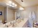 Bright bathroom with double sinks, a large mirror, and well-placed lighting fixtures at 26333 Nadir Rd # 111, Punta Gorda, FL 33983