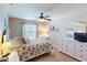 Inviting bedroom featuring a ceiling fan, a comfortable bed, and a dresser with a TV at 26333 Nadir Rd # 111, Punta Gorda, FL 33983