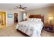 Comfortable bedroom featuring a king-size bed, ceiling fan, and view to the walk-in closet at 26333 Nadir Rd # 111, Punta Gorda, FL 33983
