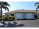 Charming home exterior with a paved driveway, two-car garage, complemented by neat landscaping at 26333 Nadir Rd # 111, Punta Gorda, FL 33983