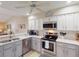 Bright kitchen with stainless steel appliances, quartz countertops, and modern lighting at 26333 Nadir Rd # 111, Punta Gorda, FL 33983