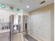 Close-up of a stainless steel refrigerator, cabinets and an open doorway leading to a bathroom at 26333 Nadir Rd # 111, Punta Gorda, FL 33983