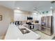 Modern kitchen featuring stainless steel appliances, pristine white cabinetry, and a convenient breakfast bar at 26333 Nadir Rd # 111, Punta Gorda, FL 33983