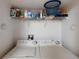 This laundry area offers a washer and dryer, along with a shelf for supplies and storage at 26333 Nadir Rd # 111, Punta Gorda, FL 33983