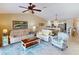 Comfortable living room with a ceiling fan, plush sofas and a view into the kitchen at 26333 Nadir Rd # 111, Punta Gorda, FL 33983
